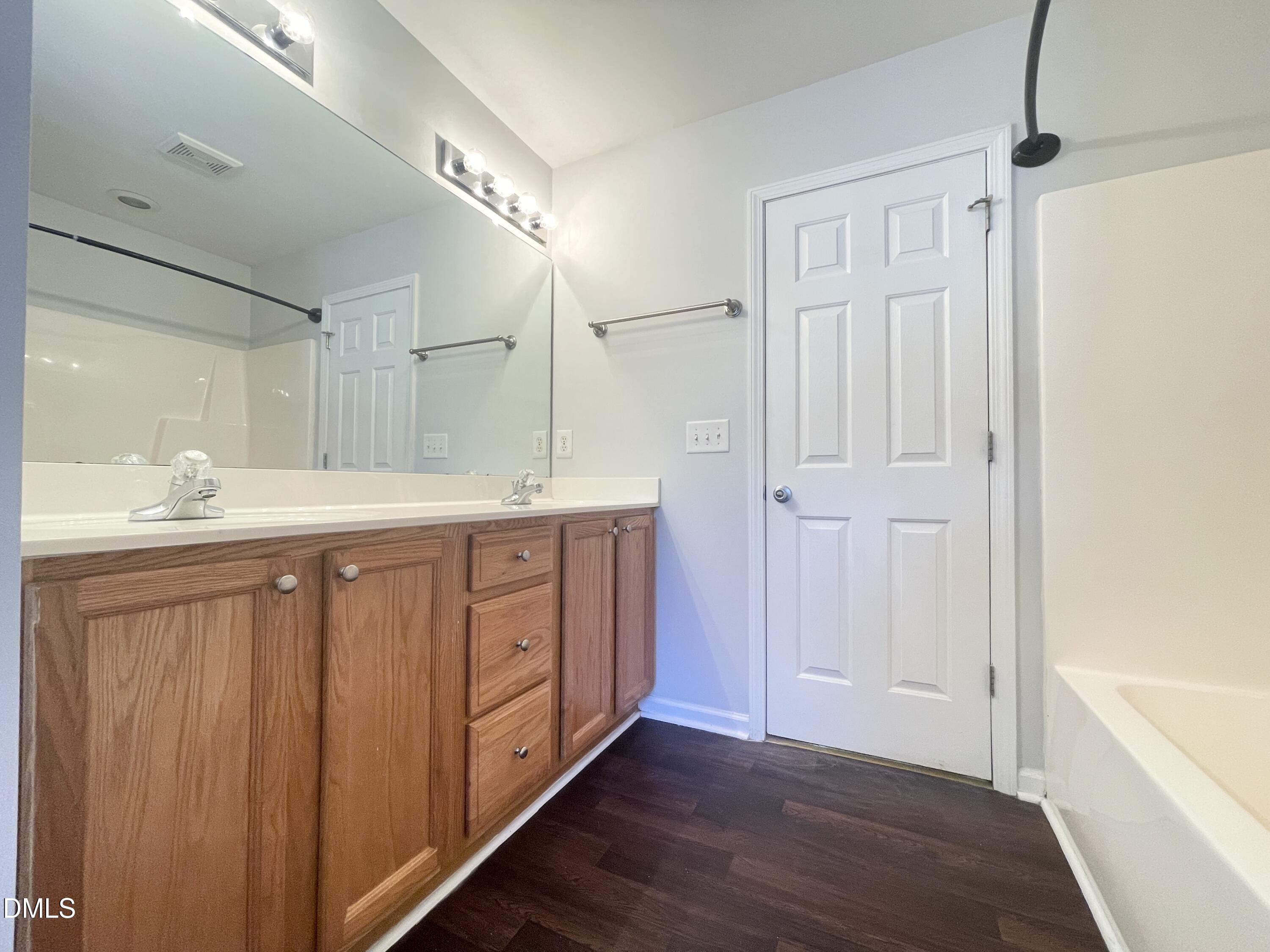 112 Taylors Creek Court Raleigh, NC 27610 - Photo 19 of 34 a spacious bathroom with a double vanity sink a mirror and a bathtub