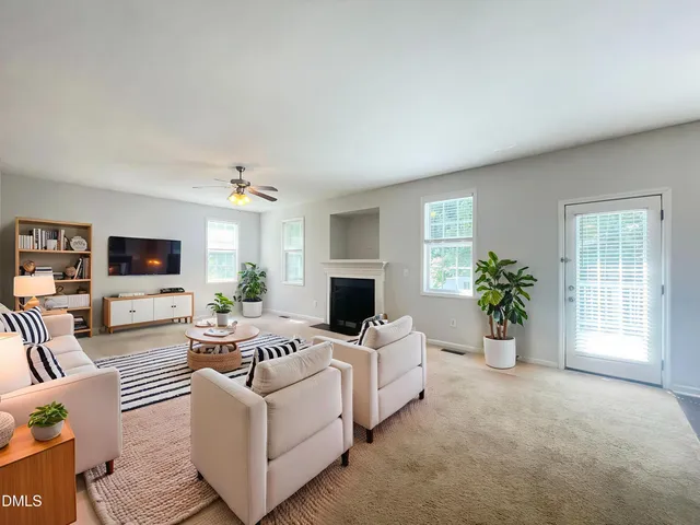 an empty room with windows and fireplace