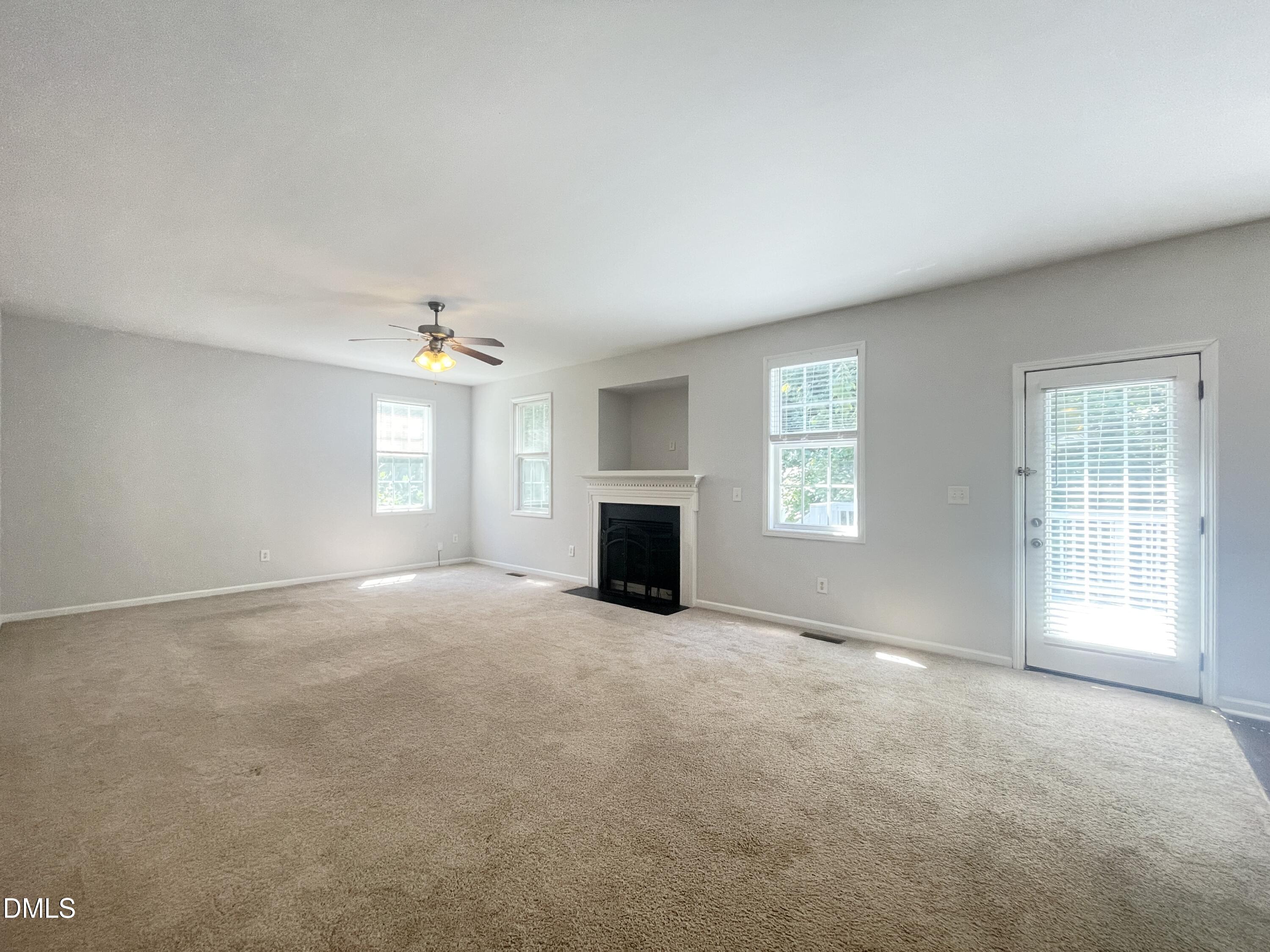 112 Taylors Creek Court Raleigh, NC 27610 - Photo 6 of 34 an empty room with windows and fireplace