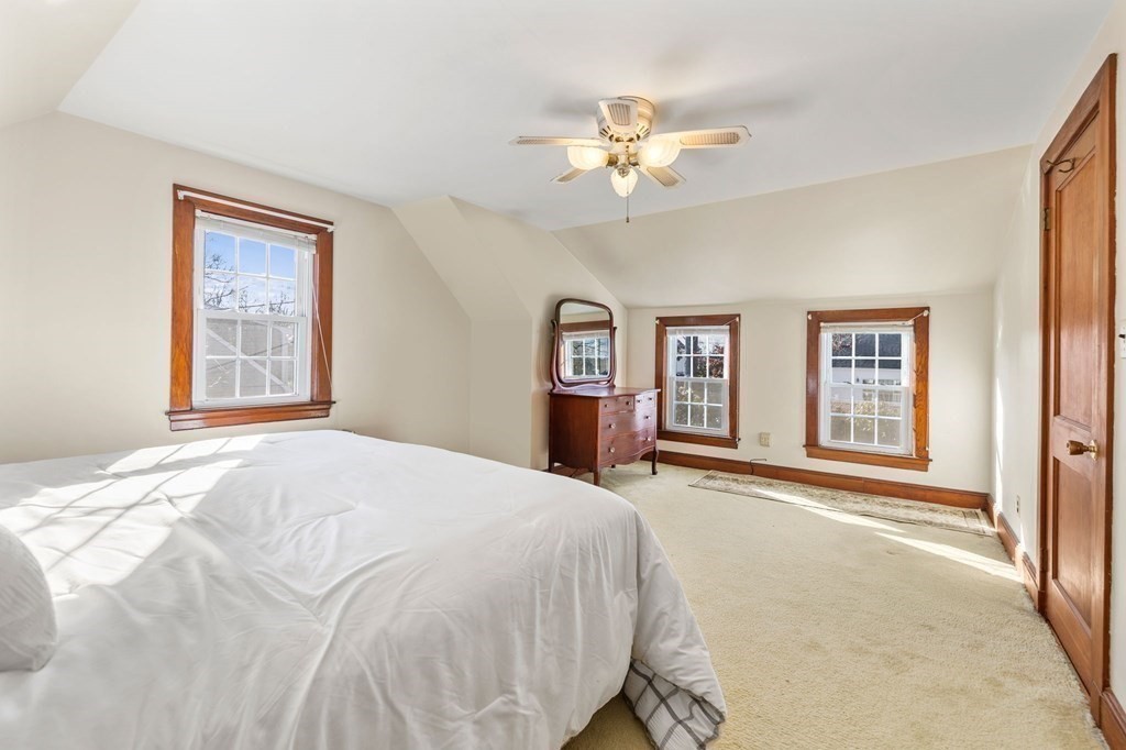 11 Russell Road Bourne, MA 02532 - Photo 10 of 16 a spacious bedroom with a large bed and a chandelier