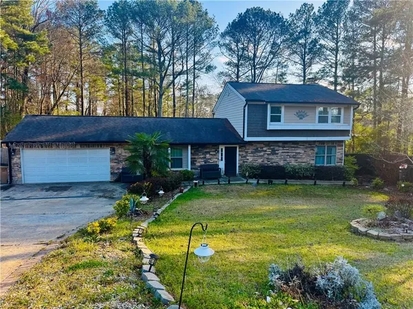 a view of a house with a yard patio and fire pit