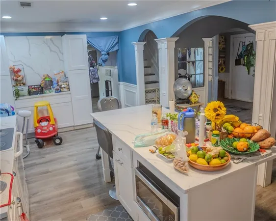 a kitchen with stainless steel appliances granite countertop a stove a refrigerator a dining table and chairs with wooden floor