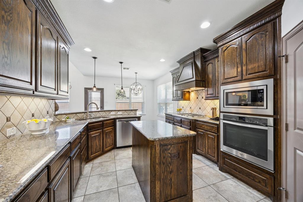 916 Redbird Lane Allen, TX 75013 - Photo 17 of 39 a kitchen with stainless steel appliances granite countertop a sink stove and refrigerator
