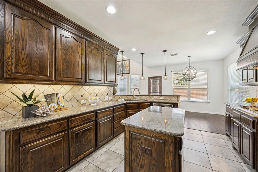 916 Redbird Lane Allen, TX 75013 - Photo 18 of 39 a kitchen with stainless steel appliances granite countertop a sink stove and cabinets