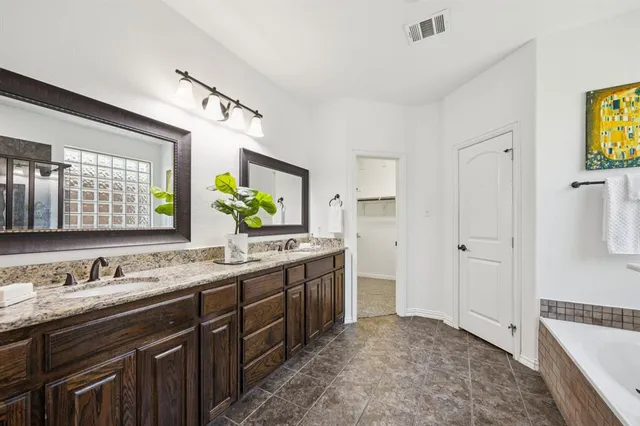 a bathroom with a tub sink and mirror