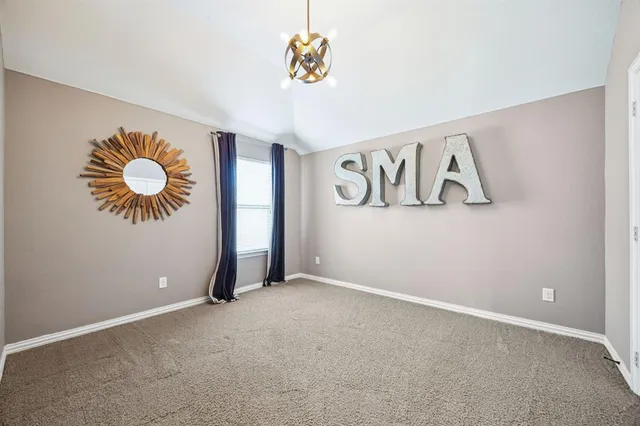 an empty room with windows and chandelier fan