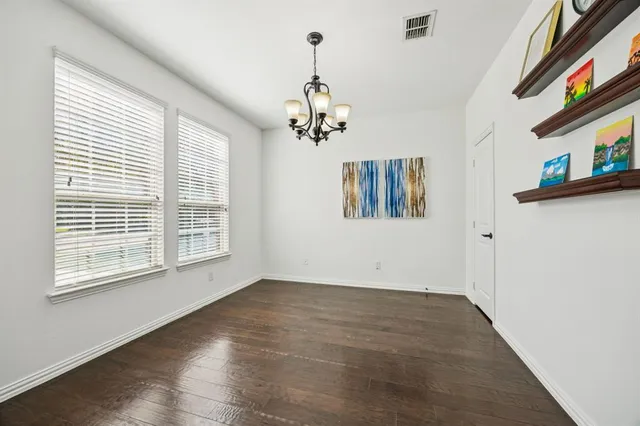 a view of a room with wooden floor chandelier and closet