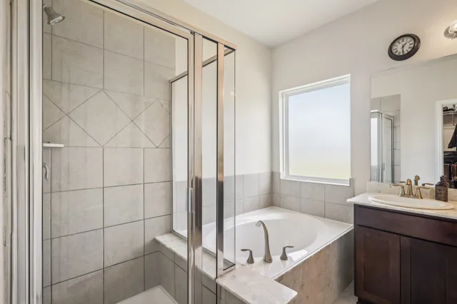 a bathroom with a tub a sink and a shower