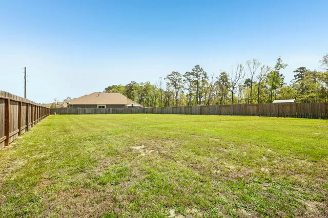 a view of swimming pool with outdoor space and trees in the background