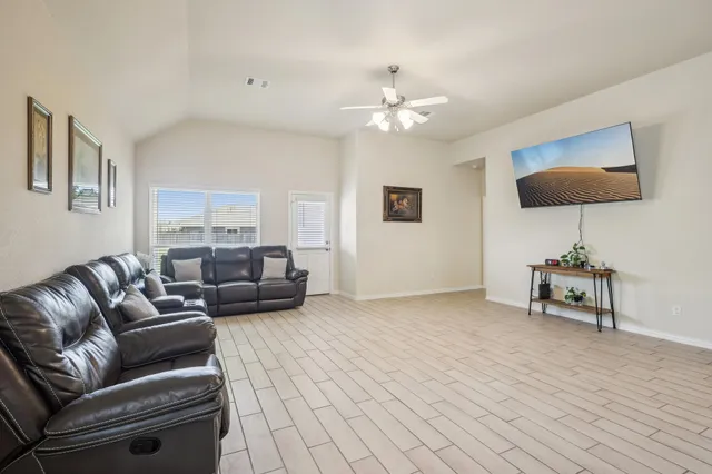 a living room with furniture and a wooden floor