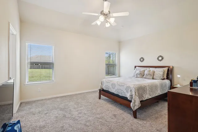 a spacious bedroom with a bed and a chandelier