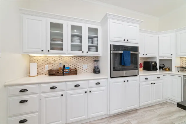 a kitchen with granite countertop a sink and white cabinets