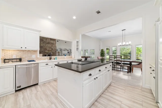 a kitchen with granite countertop a sink stove and cabinets