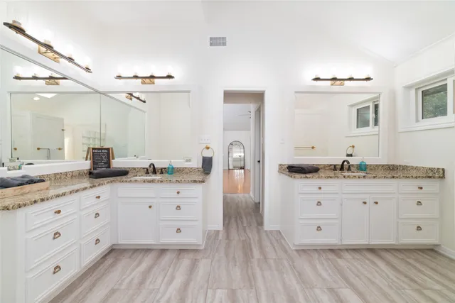 a spacious bathroom with a granite countertop sink mirror and a