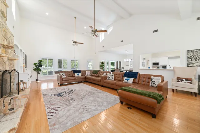 a living room with furniture kitchen view and a large window
