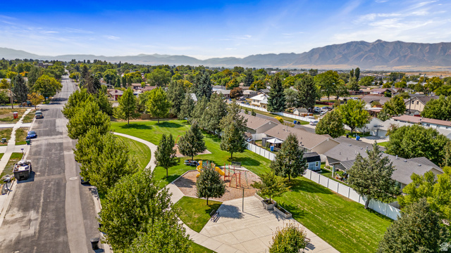 612 North 400 West Logan, UT 84321 - Photo 9 of 27 Community green space featuring a playground, mature trees, and paved walkways, bordering residential properties
