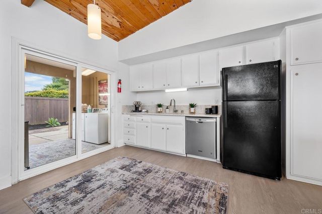 a kitchen with a refrigerator sink and cabinets