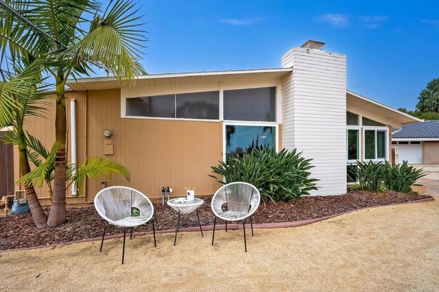 a backyard of a house with table and chairs