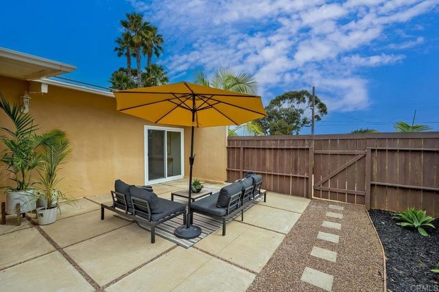 a view of a patio with a table and chairs under an umbrella