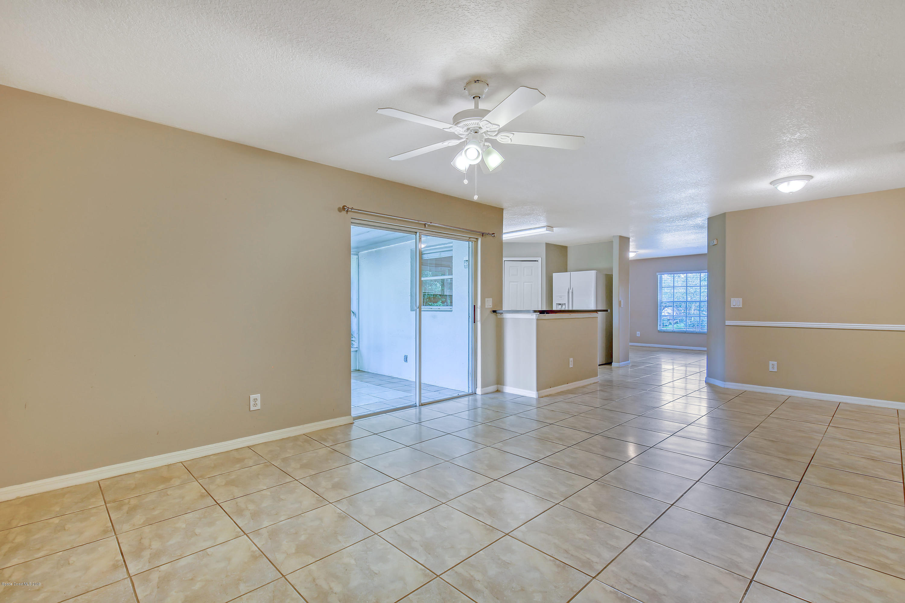 1229 Seabold Road Southwest Palm Bay, FL 32908 - Photo 8 of 24 a view of a kitchen with a sink and a refrigerator a microwave and cabinets