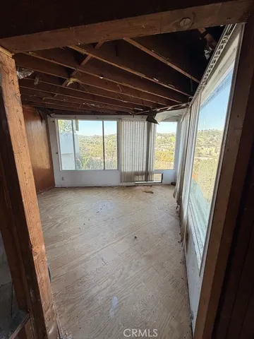 a view of a room with wooden walls and a window