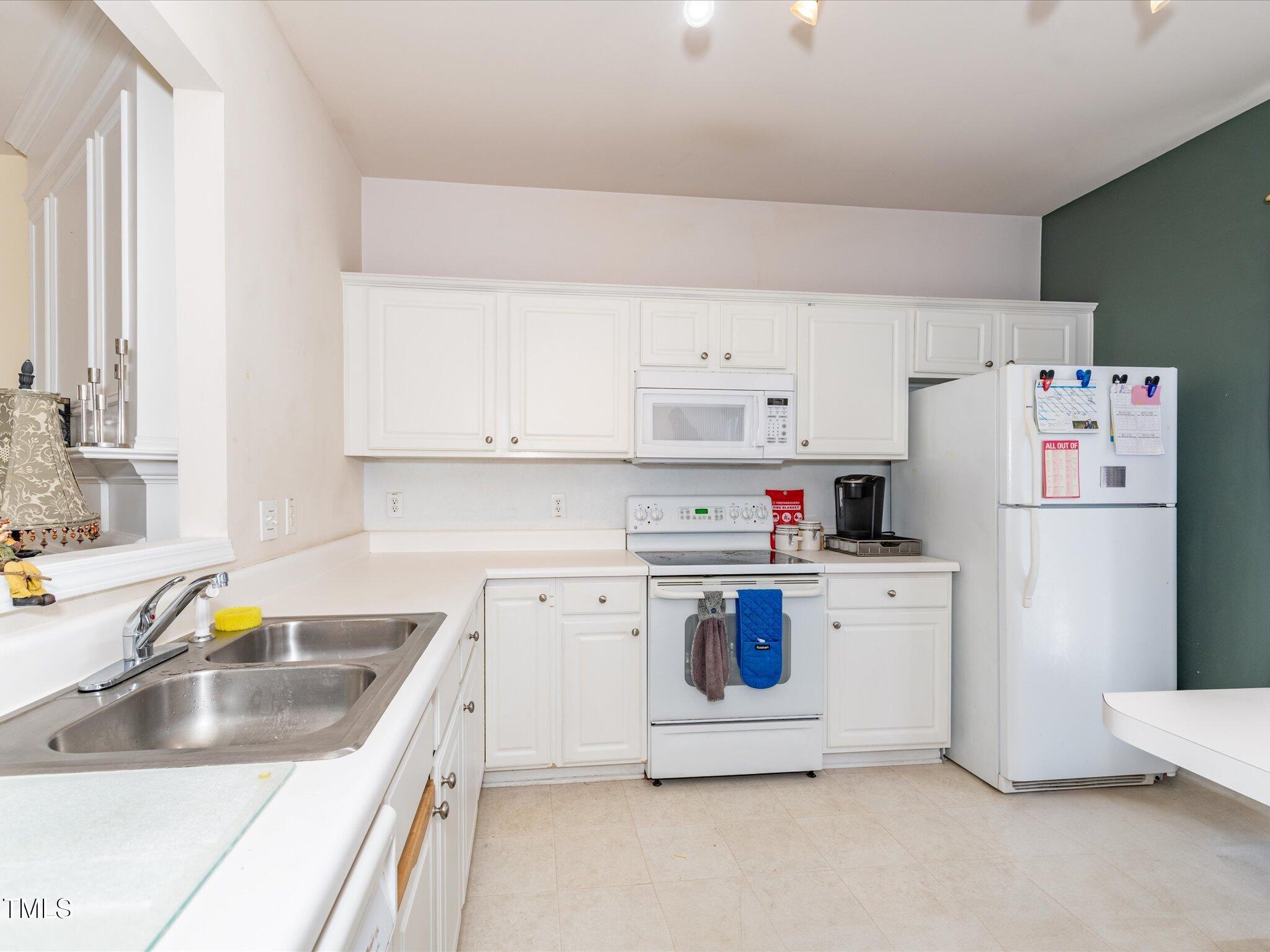 216 Ruby Walk Drive Morrisville, NC 27560 - Photo 13 of 28 a kitchen with a sink a stove and refrigerator