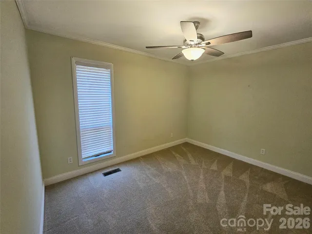 an empty room with a ceiling fan and a window