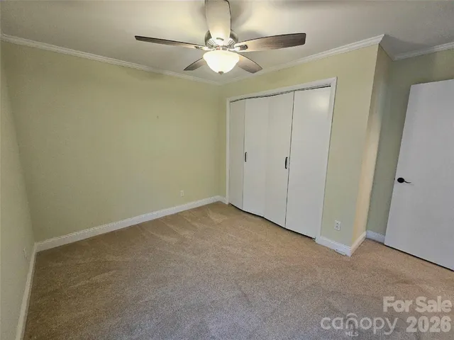 an empty room with a ceiling fan and a window