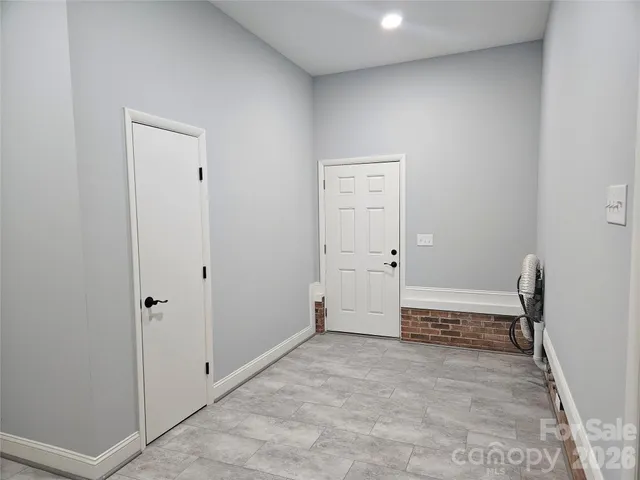 an empty room with a bench and a window