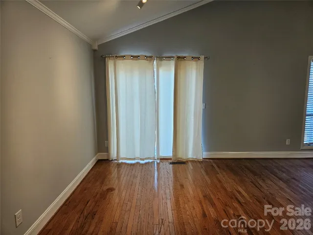 a view of a room with wooden floor and white walls