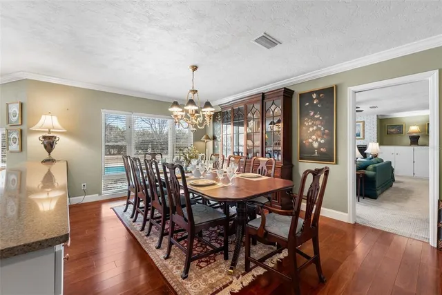 a view of a dining room with furniture wooden floor and chandelier