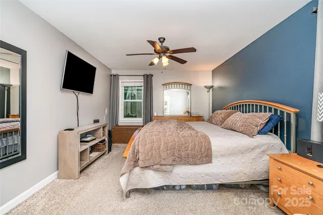 a spacious bedroom with a bed and a flat screen tv