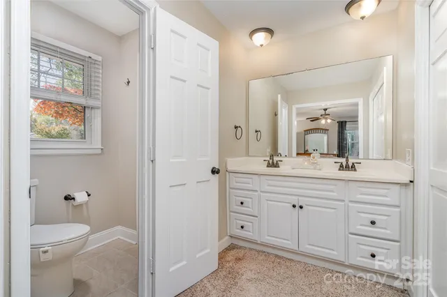 a bathroom with a granite countertop toilet sink and a mirror