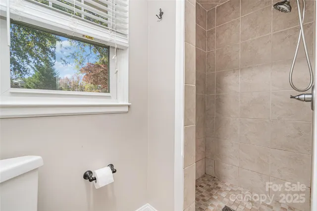 a bathroom with a painting on the wall and shower