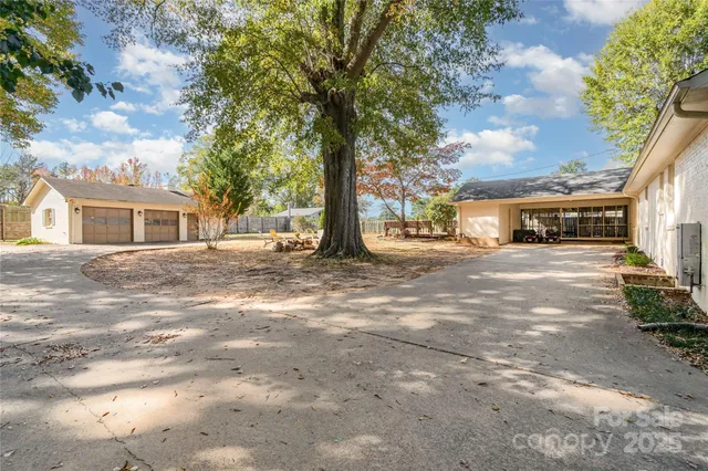 a backyard of a house with large trees and brick walls