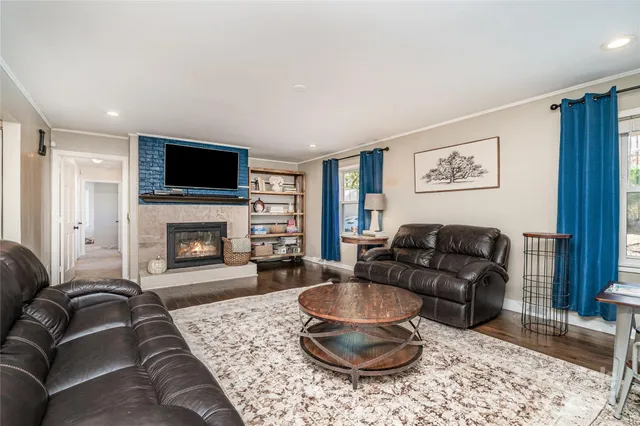 a living room with furniture a fireplace and a flat screen tv
