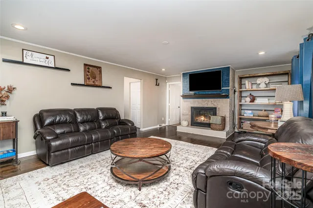 a living room with furniture a flat screen tv and a fireplace