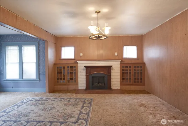 wooden floor fireplace and windows in an empty room