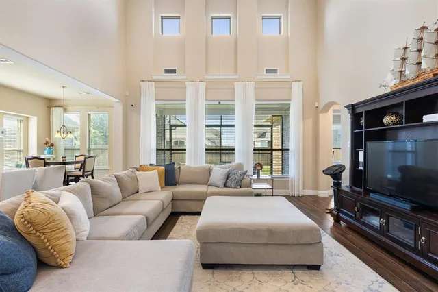a living room with furniture a flat screen tv and a large window