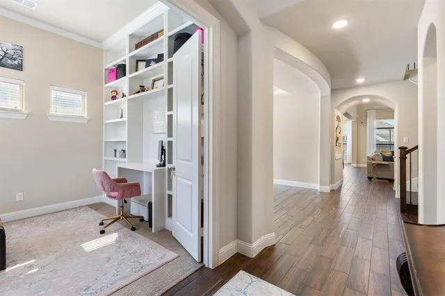 a view of a hallway with wooden floor and workspace