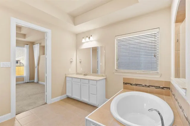 a spacious bathroom with a bathtub sink and mirror