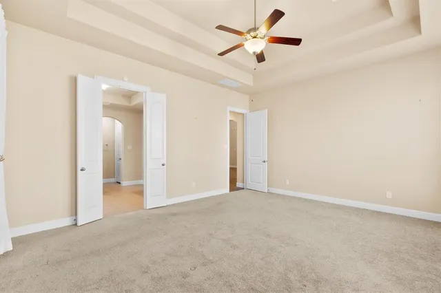 an empty room with closet and a ceiling fan