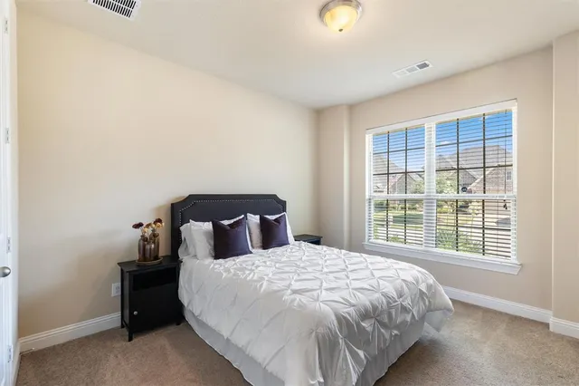 a bed sitting in a bedroom next to a window