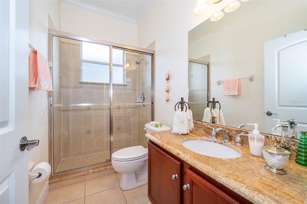 1607 Oak Hollow Road Clermont, FL 34711 - Photo 13 of 30 a bathroom with a granite countertop sink a toilet a mirror and shower