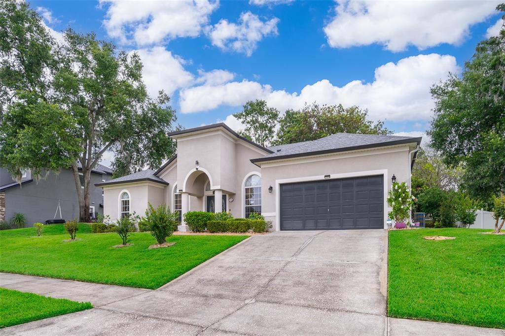 1607 Oak Hollow Road Clermont, FL 34711 - Photo 18 of 30 a front view of a house with a yard and garage
