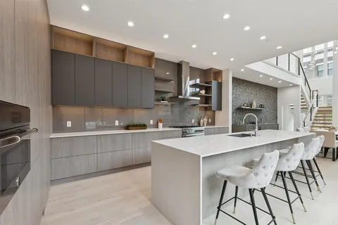 a large kitchen with kitchen island a sink a stove a refrigerator and a counter top space