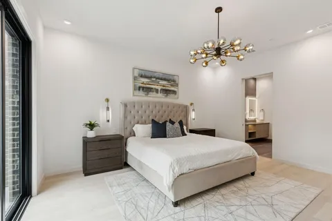 a bedroom with a bed chandelier and dresser