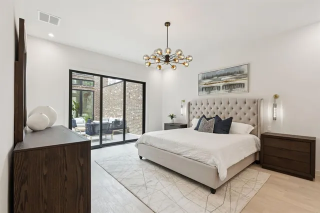 a bedroom with a large bed and a chandelier