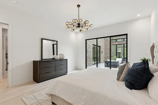 a bedroom with a bed window and a chandelier