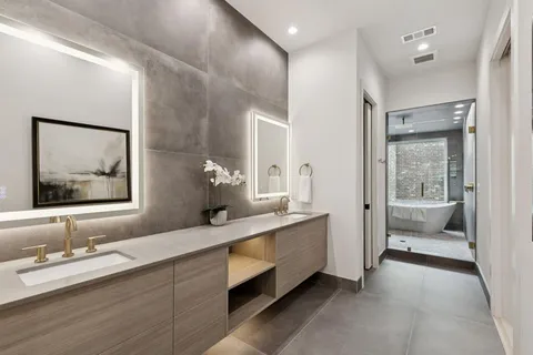 a en suite bathroom with a double vanity sink and a large mirror